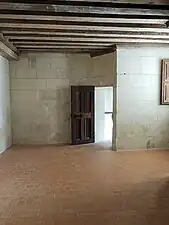 Pièce claire aux murs blancs et des poutres au plafond, à l'entresol du château de Chambord.