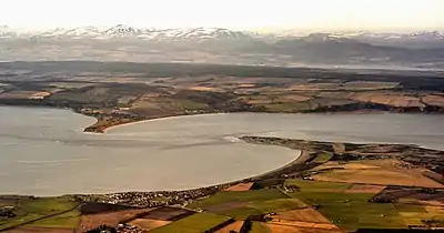 À la pointe gauche Chanonry Point (en) avec Fortrose à sa droite et le Fort George en face avec au loin le Cromarty Firth.
