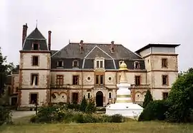 photo couleur d'un château de style XVIIIe siècle à toit en ardoise. Au premier plan, un stoupa orne le parc.