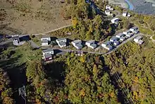 Petites maisons rectangulaires et grises.