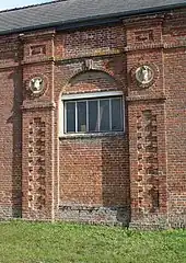 Mur de ferme orné de deux têtes d'animaux.