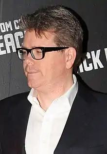 Christopher McQuarrie portant des lunettes, une chemise et une veste.