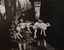 Claude et Danielle, enfants en 1944, dans la ferme Grandou avec chacun un agneau dans les bras