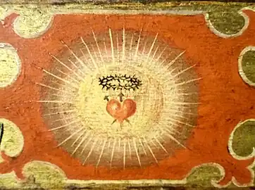 Détail d'un panneau représentant le Cœur rayonnant de Jésus-Christ, prémices à la dévotion du Sacré-Cœur.
