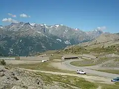 En arrière, les baraquements militaires dans les derniers hectomètres de l’ascension et la vue sur le massif des Écrins.
