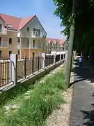 Photographie d'une rue bordée d'un immeuble neuf.