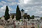Photographie en couleurs d'une église en arrière-plan d'un cimetière.