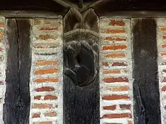 Photographie en couleurs d'un montant de bois gravé d'un animal fabuleux