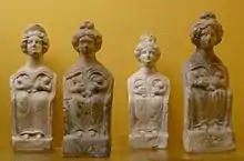 Photographie de plusieurs statuettes représentant un personnage féminin allaitant simultanément deux bébés.