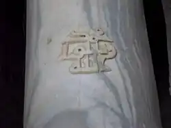 Détail d'un fût en marbre blanc veiné. Il est gravé d'une inscription arabe, réalisée en caractères coufiques en relief « Mahomet messager d'Allah ».