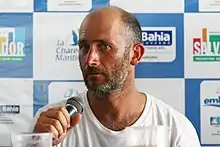 Portrait, barbu, de trois quarts, micro en main.