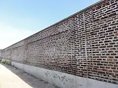 Le mur d'enceinte subsiste dans la partie sud-ouest du carreau.