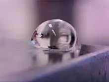 Photographie rapprochée d'une goutte sur une feuille tendue de PDMS.