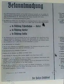 Photographie d'une affiche rédigée en allemand et en polonais.