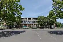 Aperçu de l'entrée du Palais des Sports de Dijon entre les arbres, où évolue la JDA Dijon