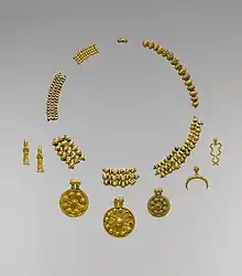 Perles en or formant un collier et pendentifs symbolisant des divinités trouvés dans le « trésor de Dilbat », milieu du IIe millénaire av. J.-C. Metropolitan Museum of Art.
