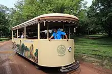 Véhicule léger routier de transport collectif. Il est non vitré et sur son flanc sont peints des représentations des principaux sites du parc.