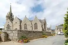 Vue du sud-sud-est. On voit principalement les quatre pignons sud (dont un porche à deux niveaux). Au-dessus, à gauche, apparaît le haut du clocher-mur. À droite, on ne voit qu'un pan du chevet.