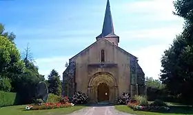 L'église du Vilhain avec la pierre Chevriau (menhir) à gauche.