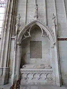 Enfeu au soubassement décoré d'une frise de quadrilobes et surmonté d'un niche en arcade trilobée dans une voussure à deux rouleaux.