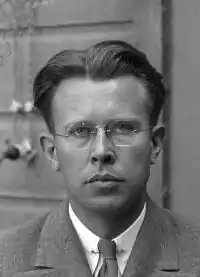 Photo en noir et blanc. Homme portant des lunettes.