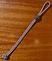 Erse à bouton ouverte, une simple boucle fermée par un nœud de sifflet du bosco sur laquelle coulisse un bonnet turc pour réduire la taille de la boucle.