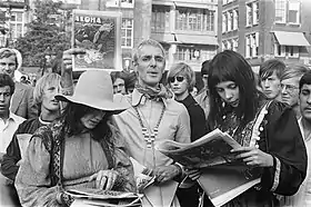 photo en noir et blanc d'un groupe de personnes lisant un magazine
