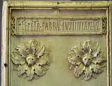 Photographie d'un morceau de marbre sculpté présentant un patronyme écrit en latin