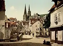 Photochrome sur lequel apparaissent des bâtisses, des passants marchant sur un pont et une cathédrale en arrière-plan