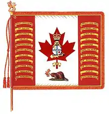 Un drapeau blanc avec deux bandes rouges de chaque côté avec 11 listels jaunes portant des noms de bataille dans chaque bande et, au centre, une feuille d'érable rouge sur laquelle se trouve un castor se tenant debout sur un tronc d'arbre au naturel tenant dans ses pattes un cercle blanc divisé par une croix blanche lisérée de deux bandes ondulées bleues avec une couronne au naturel dans le coin supérieur gauche et une feuille d'érable rouge dans le coin inférieur droit ; une couronne au naturel est située au-dessus du castor dans la feuille d'érable et un listel jaune portant l'inscription « III » surmonte la tige de la feuille d'érable. Un castor au naturel couché faisant face vers la gauche sur de la pelouse verte tenant une tige comportant trois feuilles d'érable aux couleurs d'automne se situe sous la feuille d'érable. Le drapeau est attaché sur un mât surmonté d'un lion doré portant une couronne et tenant une feuille d'érable faisant face à gauche