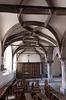 photographie en couleur montrant l’intérieur d’un bâtiment oblong couvert d’une d’une voûte retombant à droite sur des colonnes en grès rose