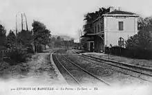Carte postale ancienne présentant les deux voies, les quais et le bâtiment voyageurs.