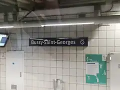 Quai de la gare avec le panneau annonçant l'arrêt « Bussy-Saint-Georges ».