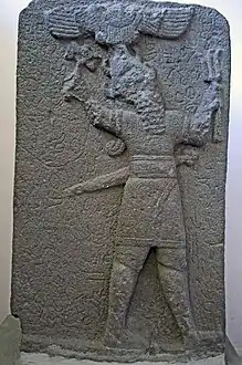Stèle hittite tardive, basalte, 700-750 av. J.-C. Le dieu de la tempête Tysup tient une hache et un faisceau d'éclairs. Au-dessus du dieu, disque solaire ailé.