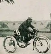 Photo d'un homme conduisant un cycle motorisé à trois roues.
