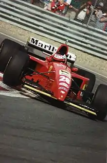 Photo de l'avant d'une monoplace rouge, avec un aileron avant jaune