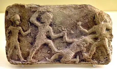 Plaque en terre cuite montrant Gilgamesh et Enkidu terrassant Humbaba. XIXe – XVIIIe siècle av. J.-C. Pergamon Museum.