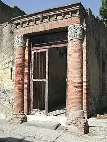 entrée encadrée de deux colonnes supportant une architrave en briques