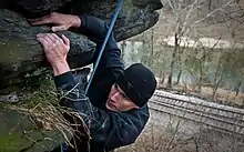 Grimpeur sur une falaise en extérieur par temps froid.