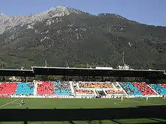 Vue d'un stade de football depuis les tribunes à la tombée de la nuit, les sièges forment les lettres « YB »
