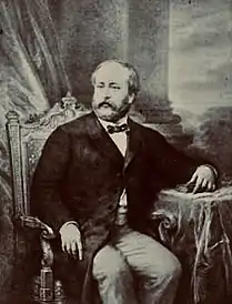 Portrait d'un homme assis à une table.