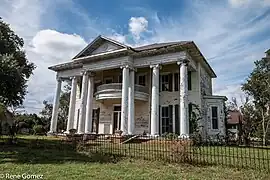 Vue d'une maison de bois blanche, à l'abandon;