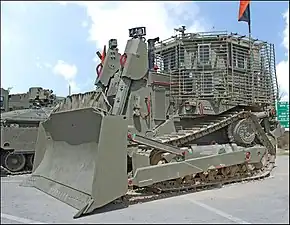 Le Caterpillar D9R (blindage de 4ème génération) de l'école du génie de combat est exposé (voir le blindage à lamelles et les poignées peintes en rouge).
