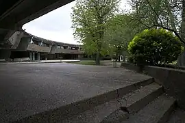le bâtiment, qui enlace sa cour arborée
