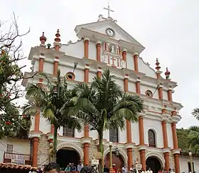 photo de la façade d'une église blanche, de style baroque, avec des parements rouges