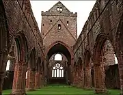 Photographie couleur de la nef ruinée d'une église gothique.