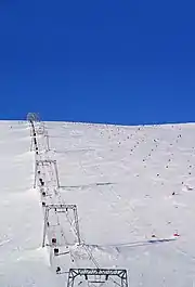 Remontée mécanique sur un paysage enneigé.