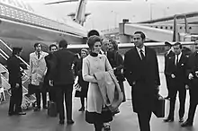 Photographie en noir et blanc d'un groupe de personnes devant un avion.