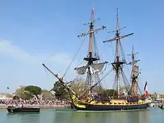 La frégate Hermione sortant du bassin des chalutiers pour accéder au chenal.