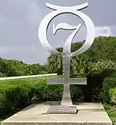 Monument argenté représentant l'emblème du programme Mercury (lui-même issu du symbole de Mercure ☿ avec le chiffre 7).